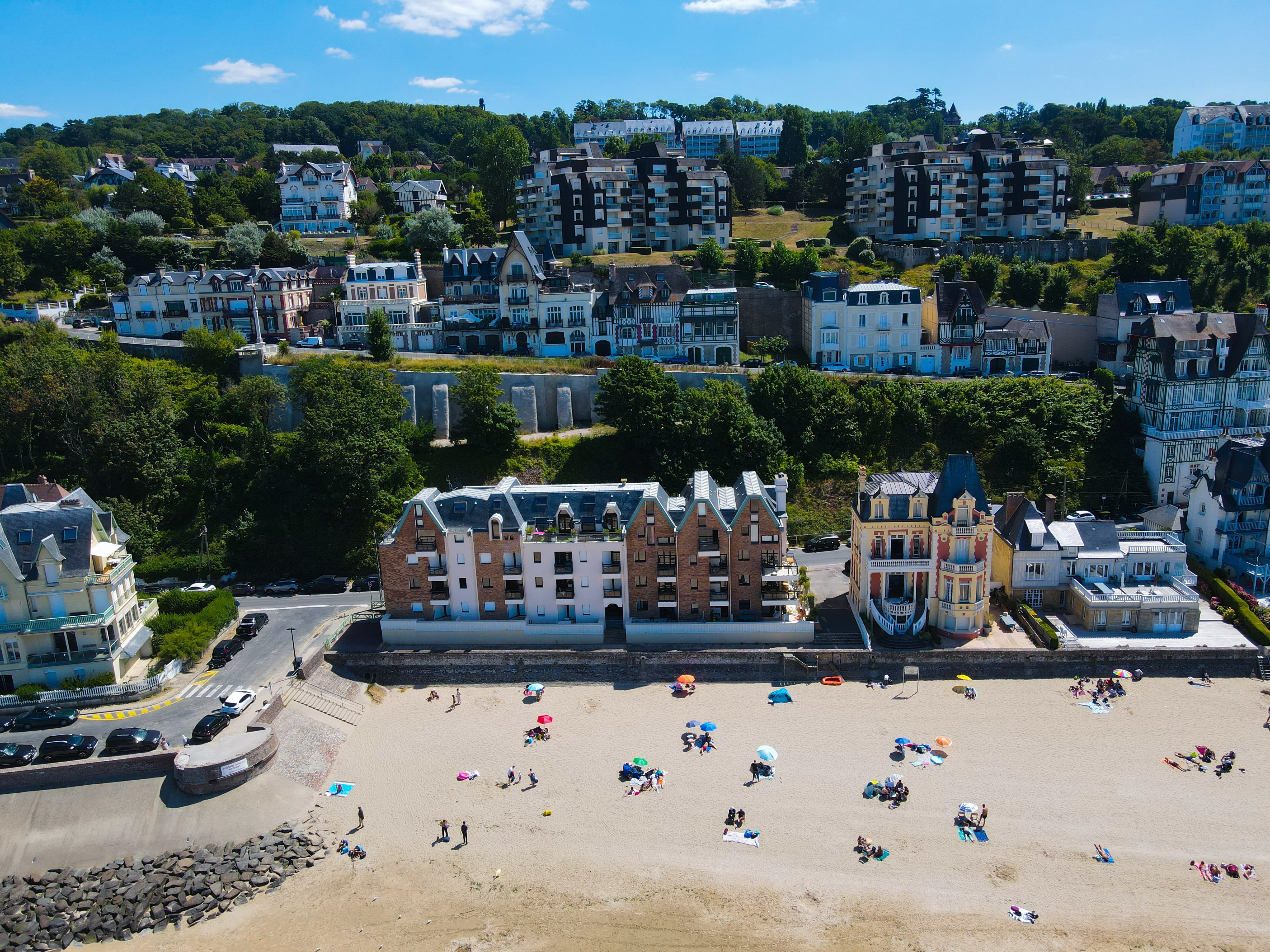 Vue aérienne de bâtiments résidentiels et d'une plage, illustrant une commune avec un fort taux de résidences secondaires.