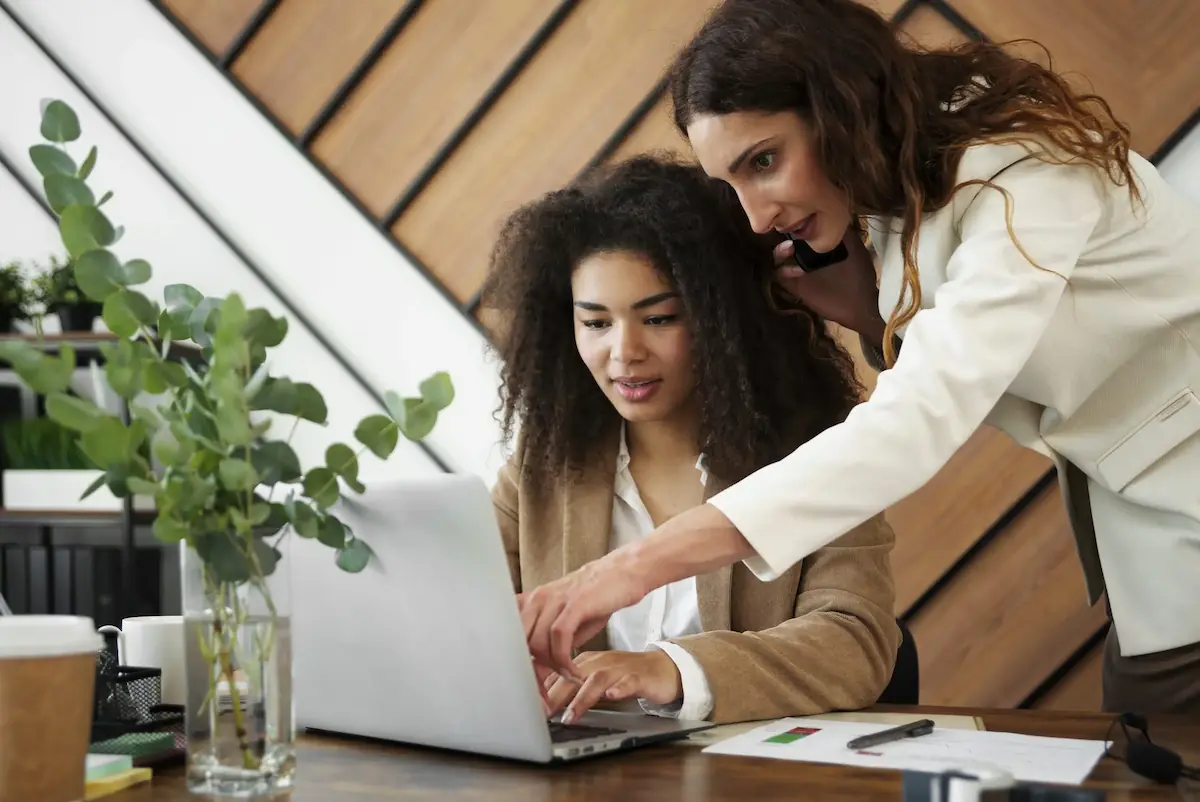 Deux femmes qui étudient la sectorisation territoriale par un outil de géomarketing